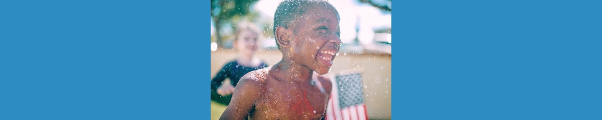 Boy Playing in Water Spray