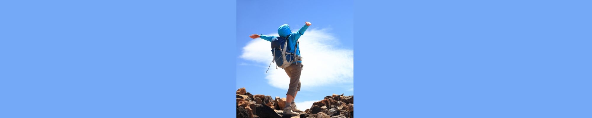 Woman on mountain top with outstretched arms