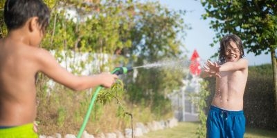Boys playing with water hose