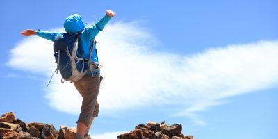 Woman on mountain top with outstretched arms